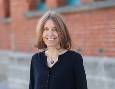 Portrait von Andrea Schneider vor einem Backsteingebäude