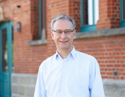Portrait von Volker Langner vor einem Backsteingebäude